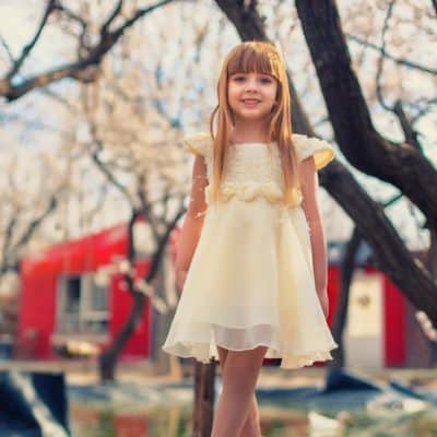 عکس هنری کودک در طبیعت کرج، دختر بچه با دسته گل سفید و نگاهی آرام - عکاسی تخصصی فضای باز آتلیه مهتا
