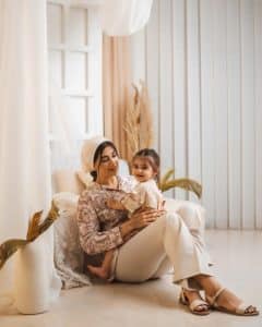 یک عکس آتلیه ای از مادر و کودک در فضایی بوهو در آغوش یکدیگر و نشسته